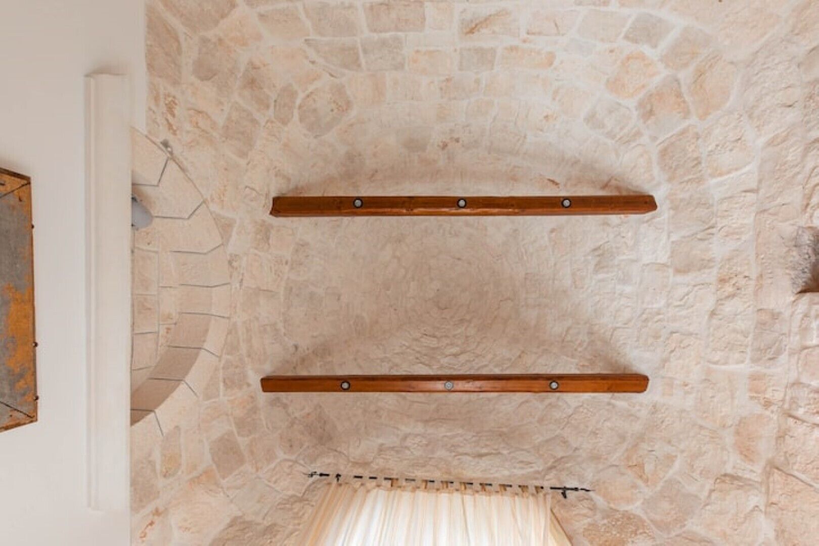 A stone wall with two wooden beams.
