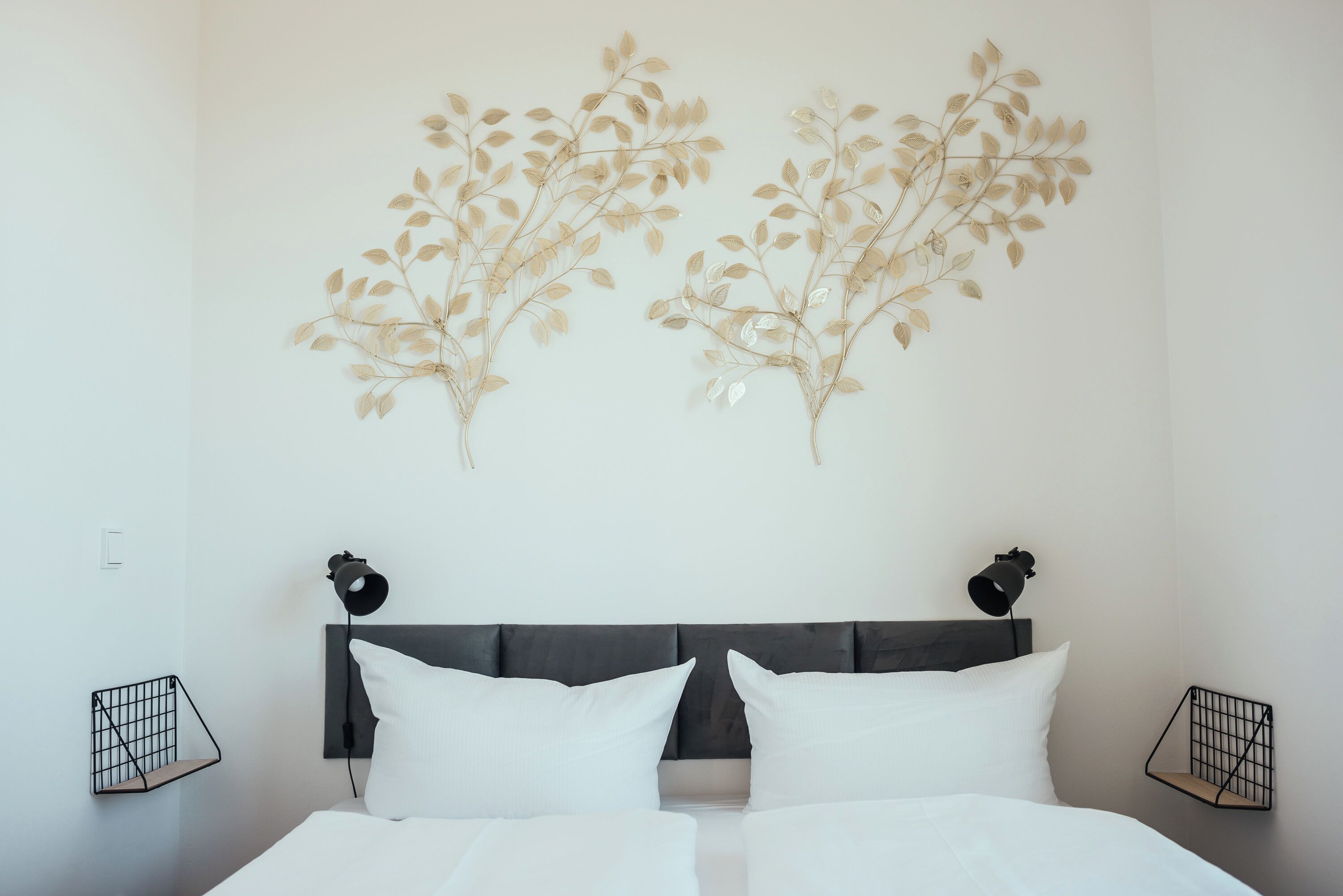 Ein Schlafzimmer mit einem Bett, zwei Wandleuchten und zwei zusätzlichen Lichtvorrichtungen.