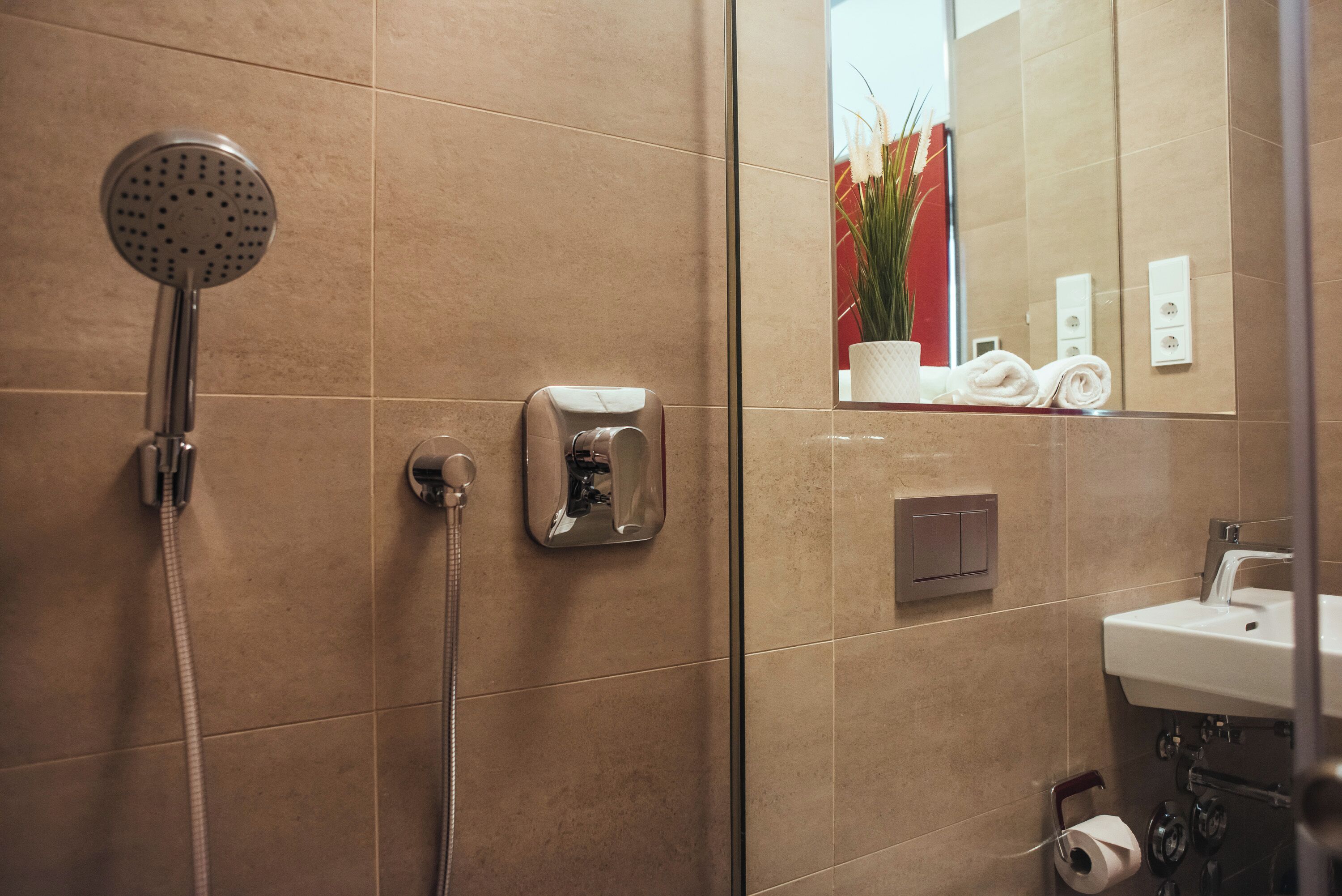 Un baño moderno con ducha, toallero, espejo y lavabo.