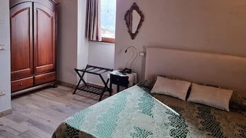 Un dormitorio con cama, escritorio, armario y ventana.