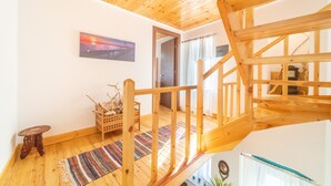 A wooden staircase leading to an upper floor, a small wooden stool, a colorful woven rug, and a framed picture on the wall. - Bekiris Traditional Inn Country House with Private Terrace, Air Conditioning & Wi-Fi (Lefkimi)