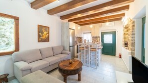 A living room with a sofa, a coffee table, and a television. - Bekiris Traditional Inn Country House with Private Terrace, Air Conditioning & Wi-Fi (Lefkimi)