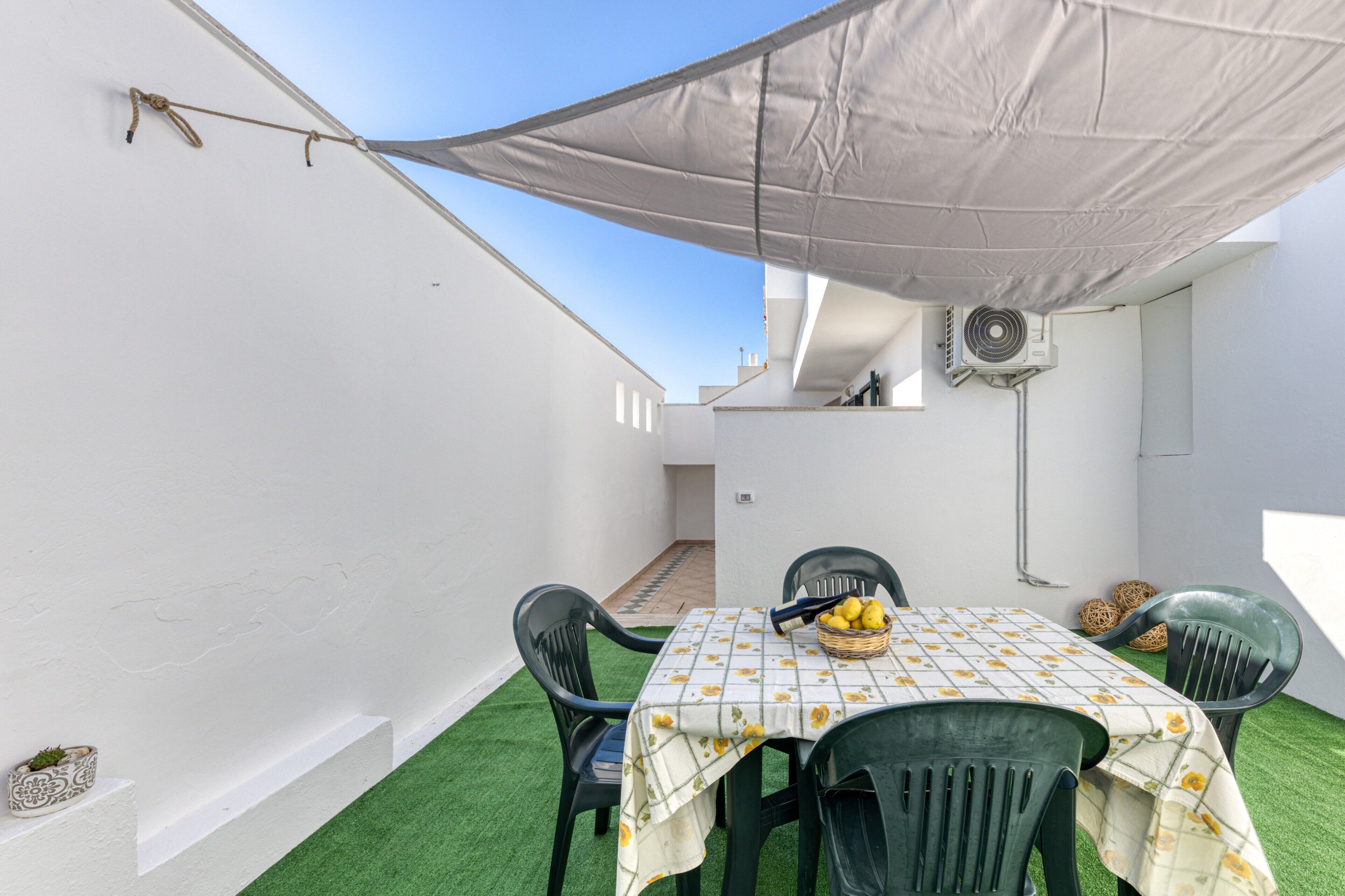 Un patio con tavolo, sedie e tovaglia.