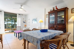 A dining area with a table, chairs, a cabinet, and a view through a glass door.