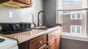 A kitchen with a stove, sink, and a dish rack. - Rustic Home w/ 2 BR - WIFI included (Louisville)