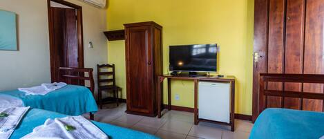 A hotel room with two beds, a television, a small refrigerator, and wooden furniture.