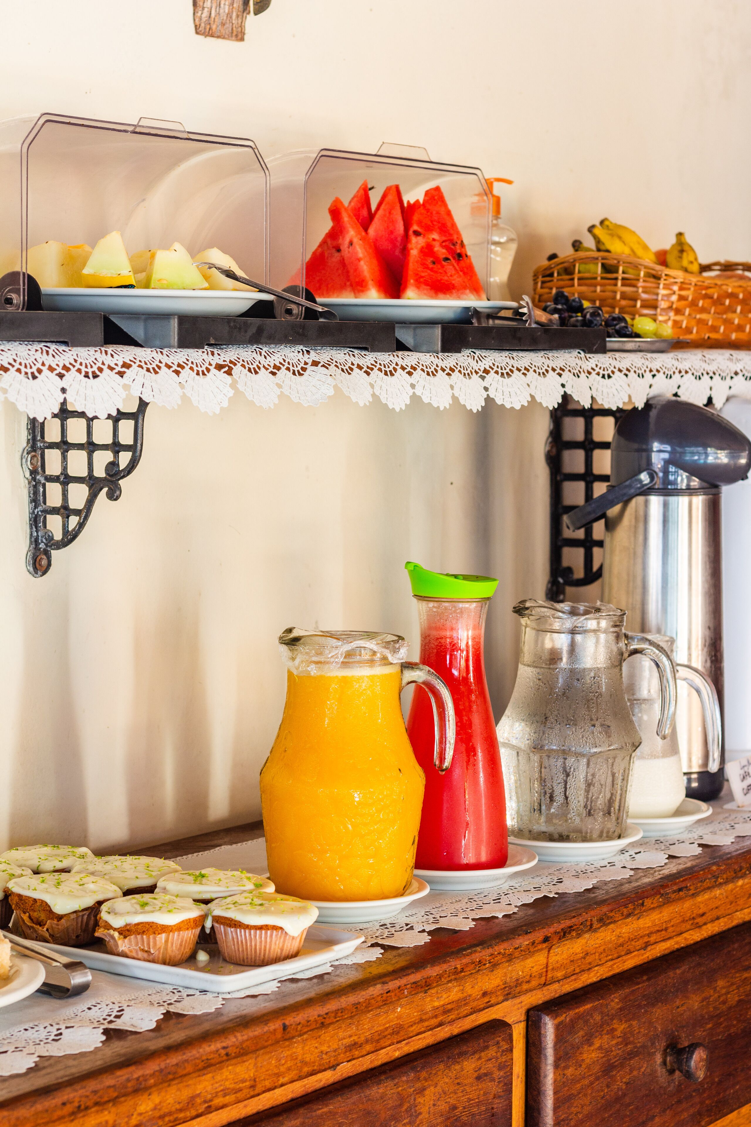 A breakfast buffet with various fruits, juices, and pastries.