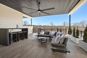 An outdoor patio with a sofa, coffee table, and bar area.