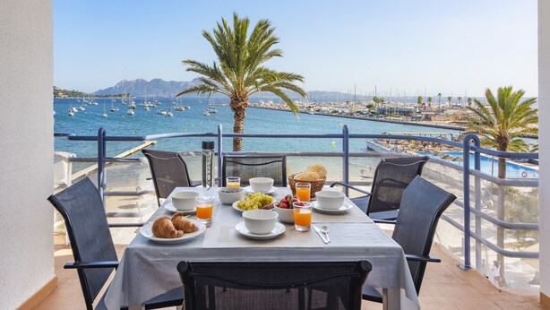 Tavola imbandita per la colazione con vista sul porto turistico e sulle barche.
