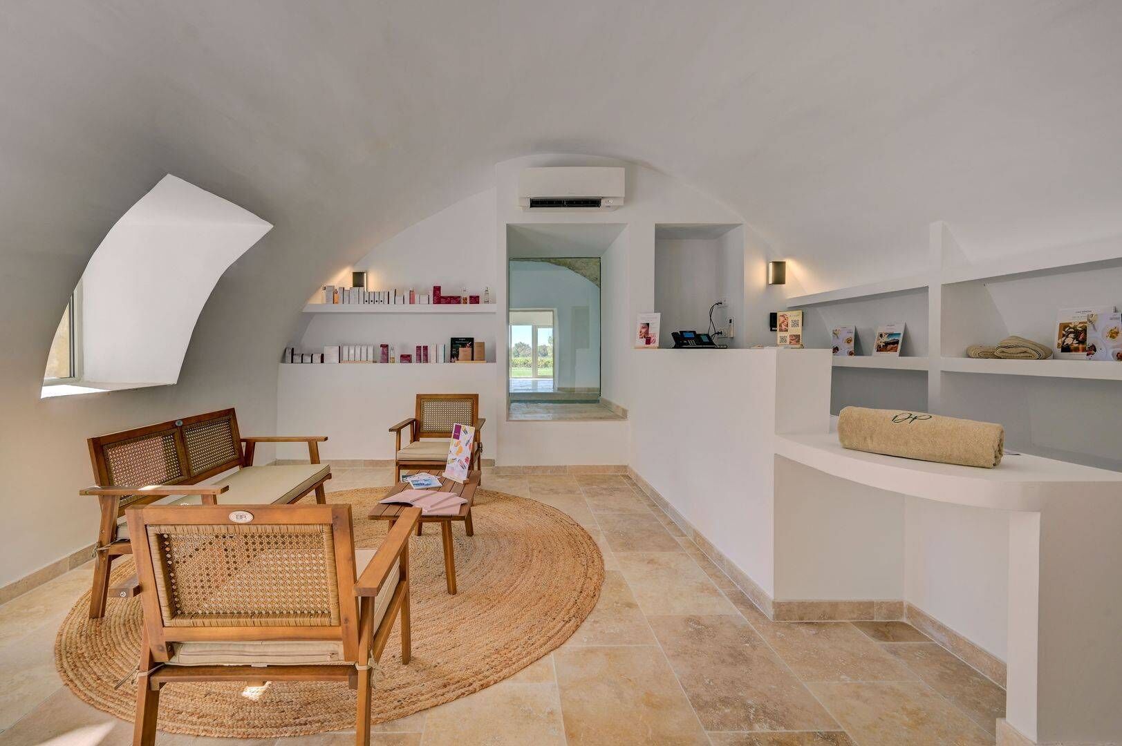Ein geräumiges Loft mit hohen Decken, einem Oberlicht, einer eingebauten Bücherwand und einer gemütlichen Sitzecke mit Holzmöbeln und einem gewebten Teppich.