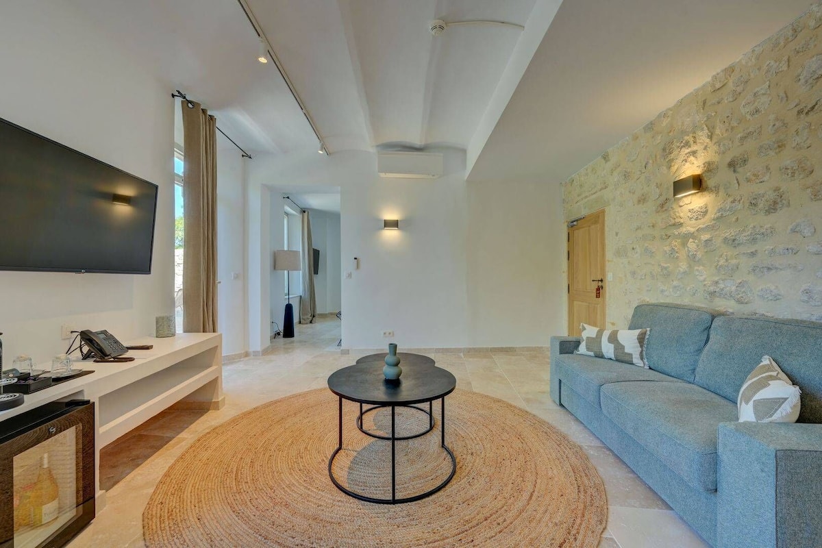 Un salon moderne avec un téléviseur à écran plat, une table basse ronde et un canapé bleu.