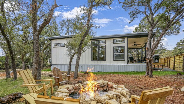 A modern house with a fire pit and outdoor seating.