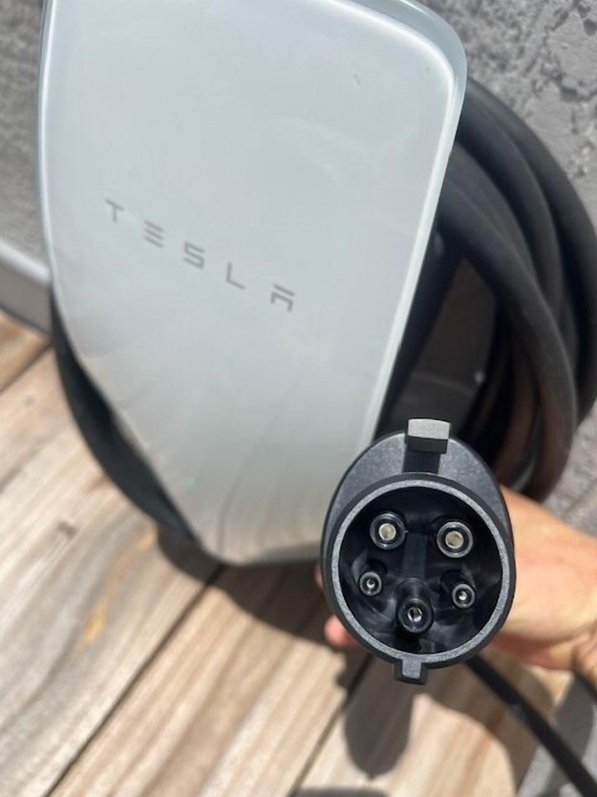 Primer plano de un cable y conector de carga para Tesla.
