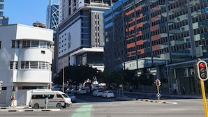 En stadsgata med moderna byggnader, en trafikljus och en grön cykelbana.