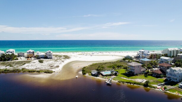 A coastal area with a beach, a marina, and residential buildings.