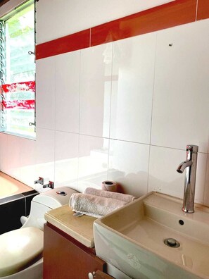 A bathroom with a bathtub, a sink, and a toilet.