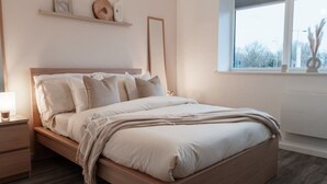 Una camera da letto con un letto di legno, comodini, una finestra vista e uno scaffale con oggetti decorativi.