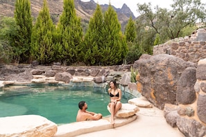 Una piscina al aire libre, sillones reclinables de piscina