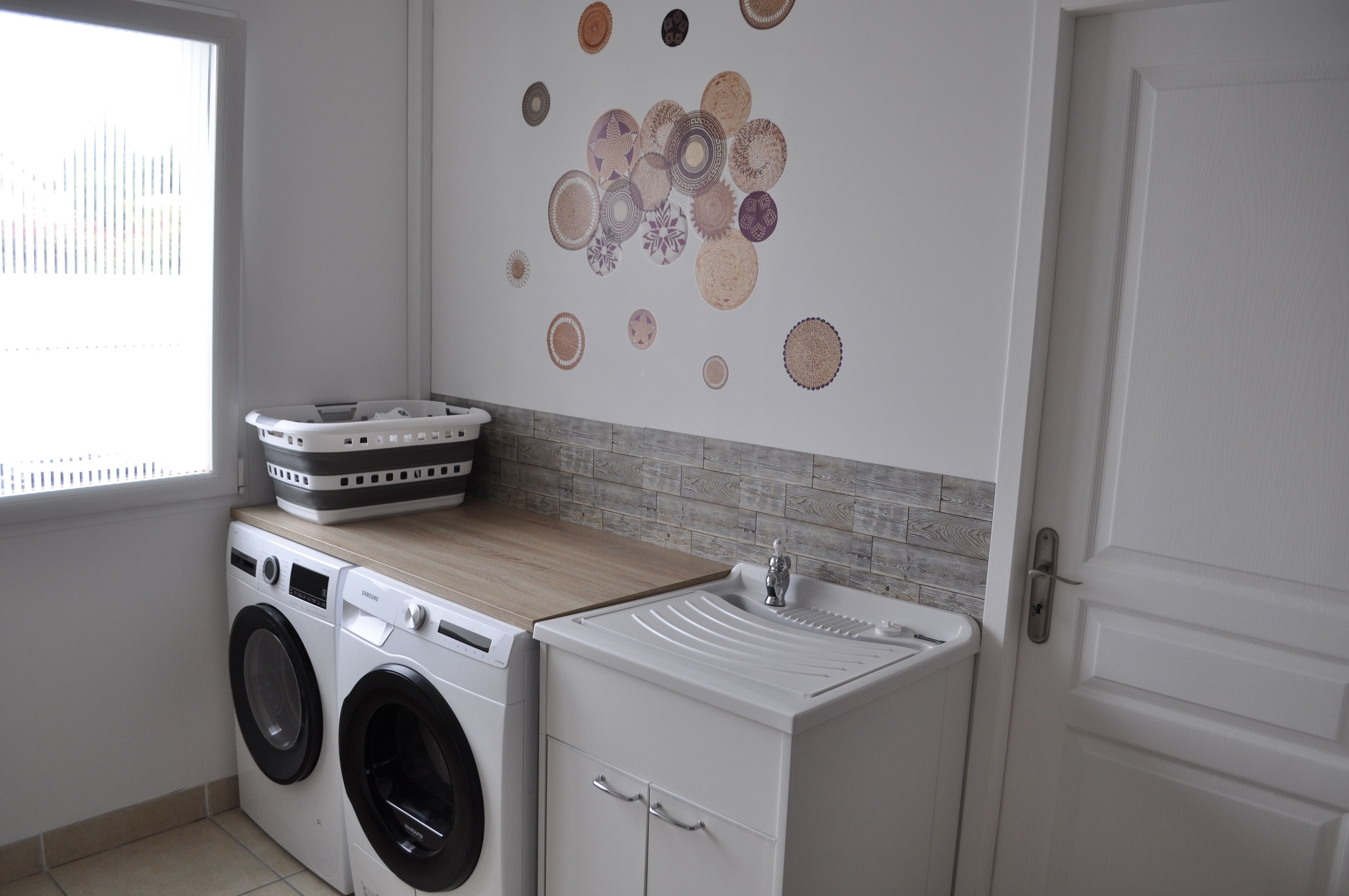 A laundry room with a washing machine, dryer, and a sink.