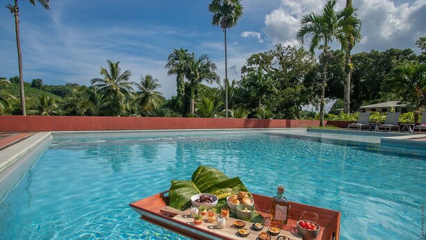 A poolside setting with a tray of food and drinks. - Habitation La Thibault Exceptional estate in the heart of Martinique (Gros-Morne)