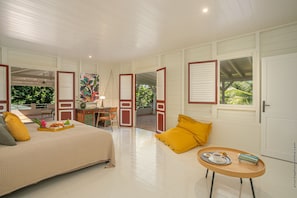 Un dormitorio espacioso con cama, una mesita y vistas al exterior.
