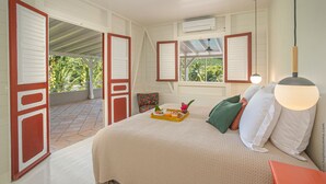 A bedroom with a bed, a tray of breakfast, a window, and an air conditioning unit. - Habitation La Thibault Exceptional estate in the heart of Martinique (Gros-Morne)