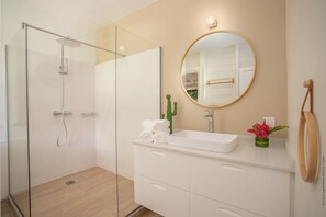 Regadera, secadora de cabello, toallas, papel de baño 