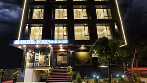 Un hotel con fachada moderna, varios pisos y una entrada destacada con escalones.