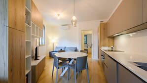 Una cocina moderna con armarios de madera, una mesa redonda y sillas grises.