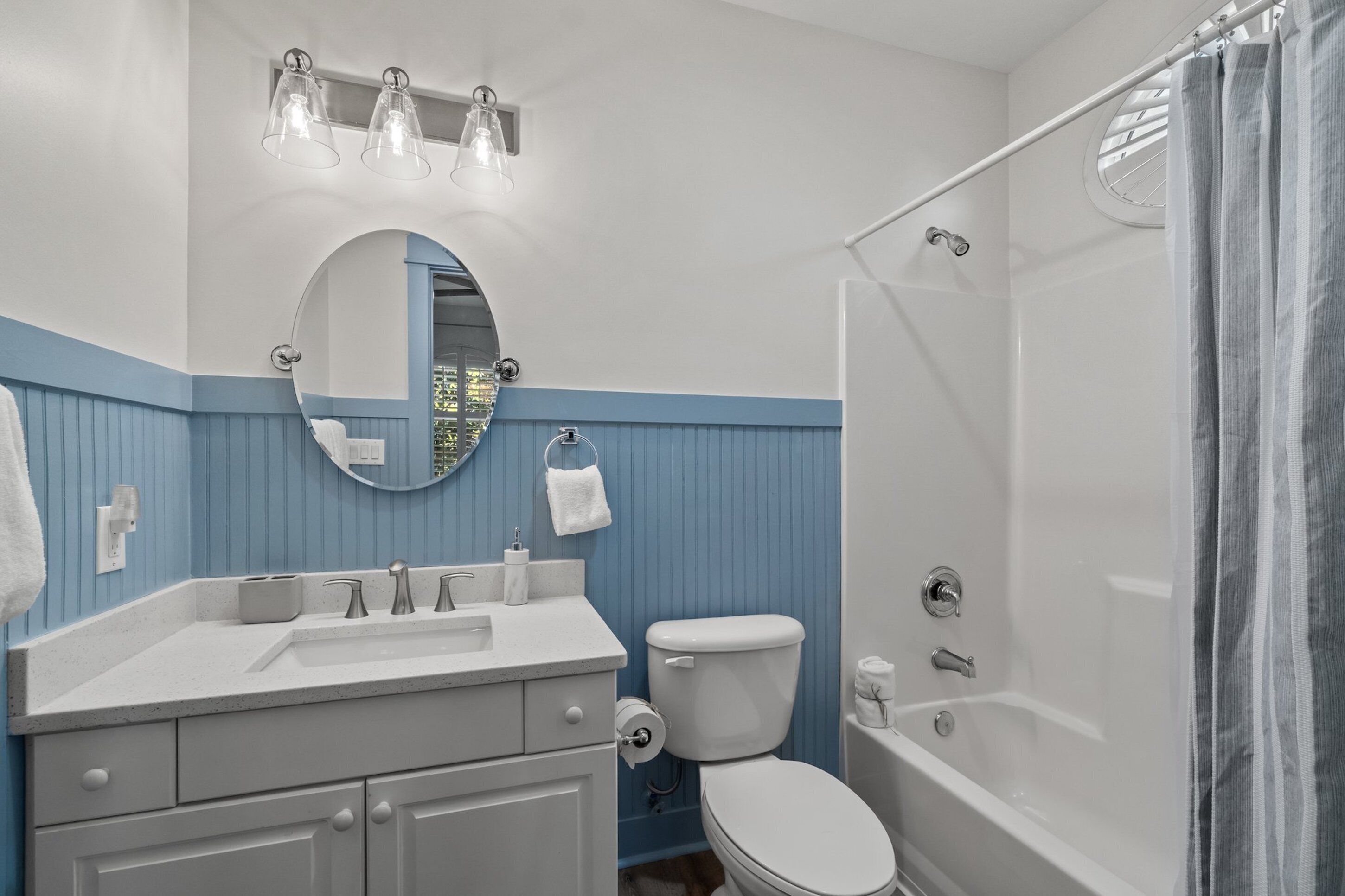 Ein Badezimmer mit Waschbecken, Spiegel, Toilette und Badewanne.