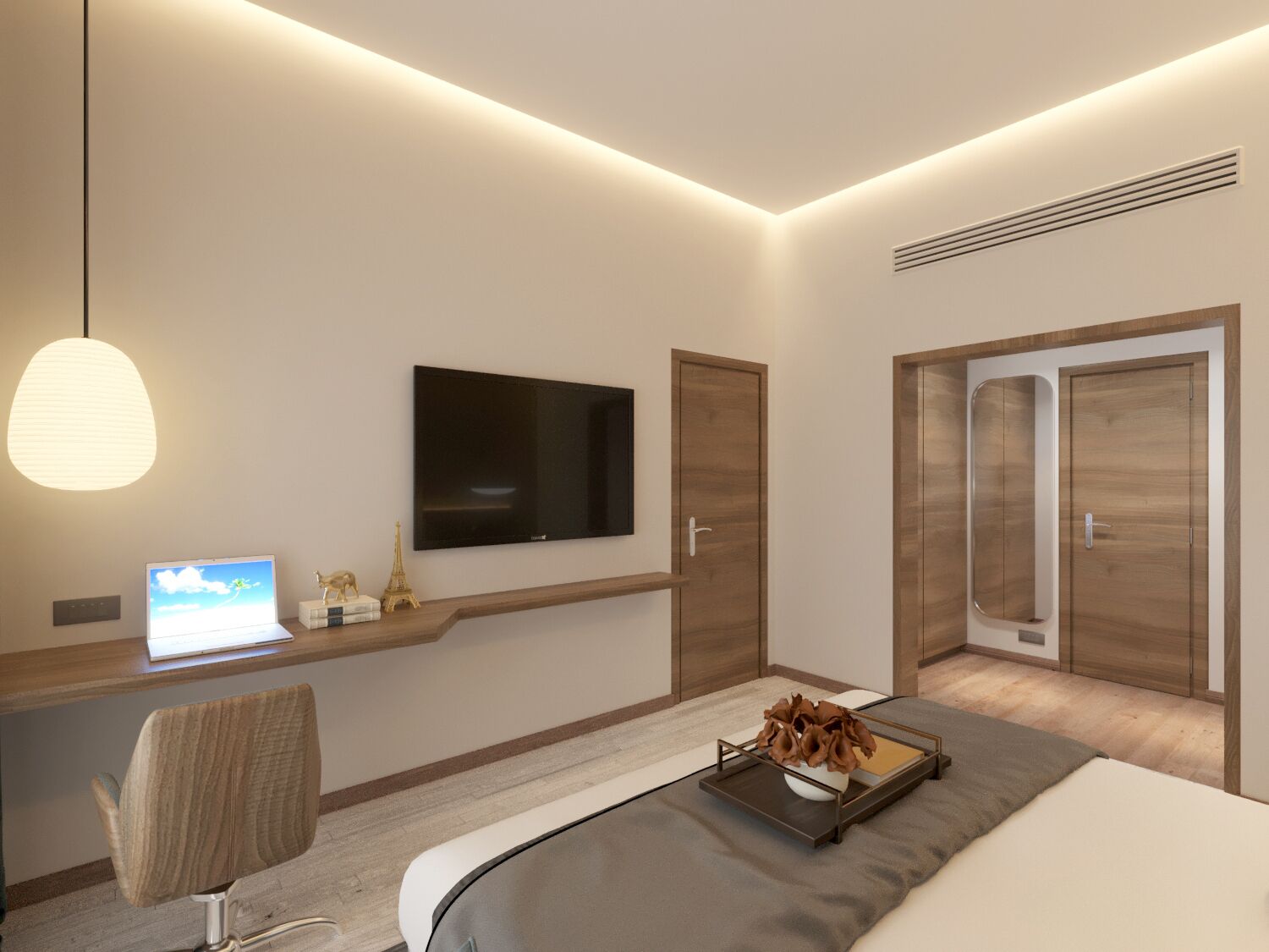 A modern hotel room with a bed, a desk with a laptop, a TV, and a wardrobe.