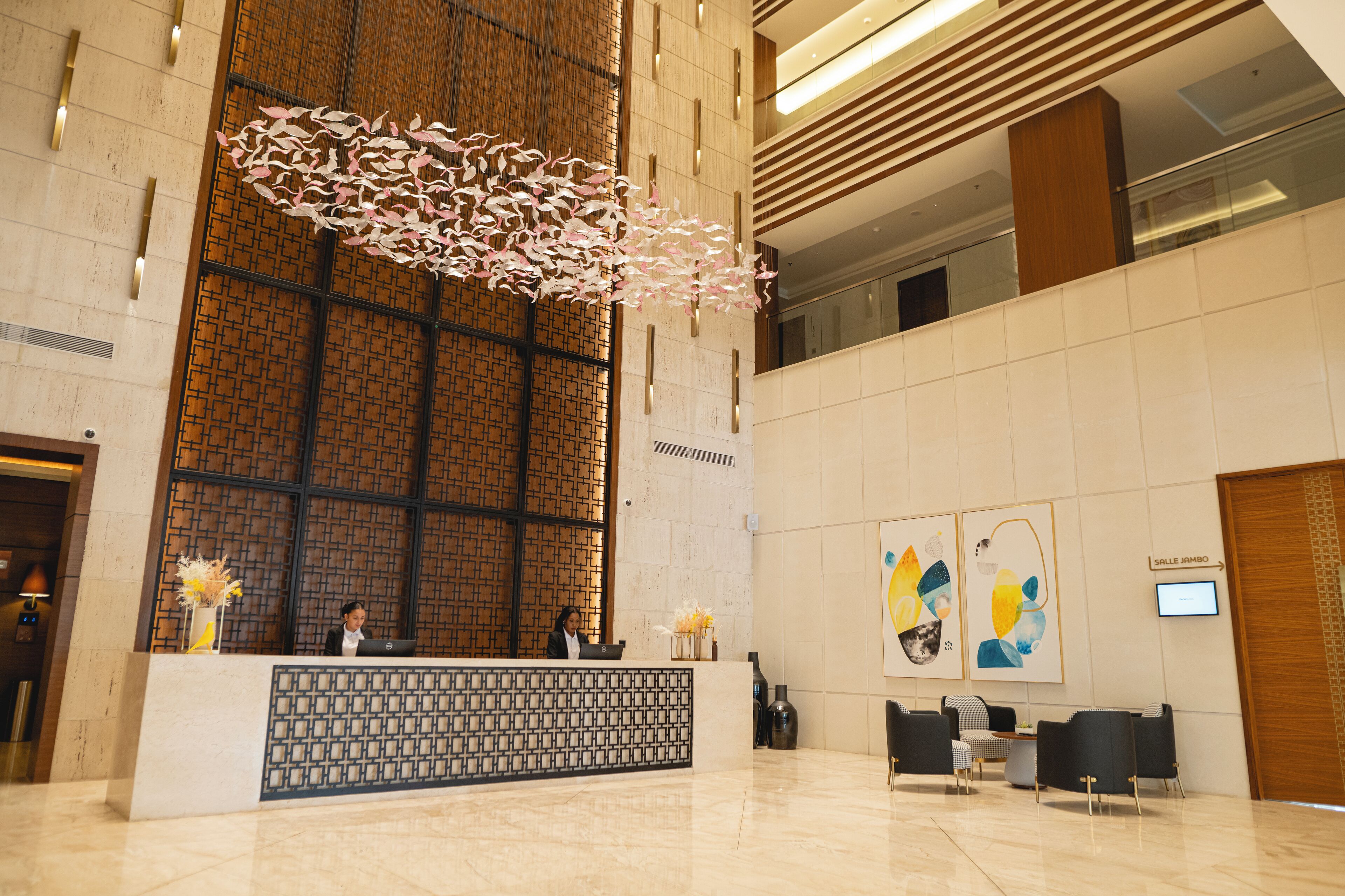 A modern reception area with a reception desk, seating, and a large decorative light fixture.