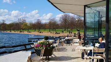 Relax in a serene outdoor seating area overlooking a park and body of water.