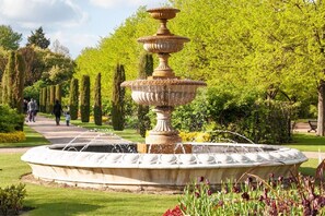 Stunning fountain surrounded by a beautifully manicured garden with flowering plants and a meandering pathway.