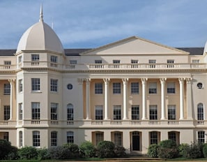 Stately building with a classical facade, featuring a central entrance and evenly spaced windows.