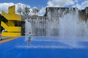Children can splash and play in the water feature surrounded by a large fountain.