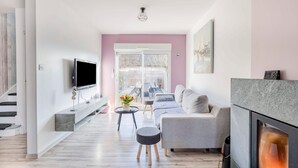 Un salon moderne avec une cheminée, un téléviseur à écran plat et un canapé.