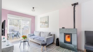 Un salon moderne avec un canapé, une cheminée et un coin repas avec des chaises.