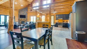 A spacious log cabin interior with a dining area, kitchen, and living room. - Sensational Views -4BR/New Hot Tub/New Firepit/Perfect for Families/No Event Fee (Gatlinburg)