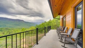 A balcony with a view of green hills and a cloudy sky. - Sensational Views -4BR/New Hot Tub/New Firepit/Perfect for Families/No Event Fee (Gatlinburg)