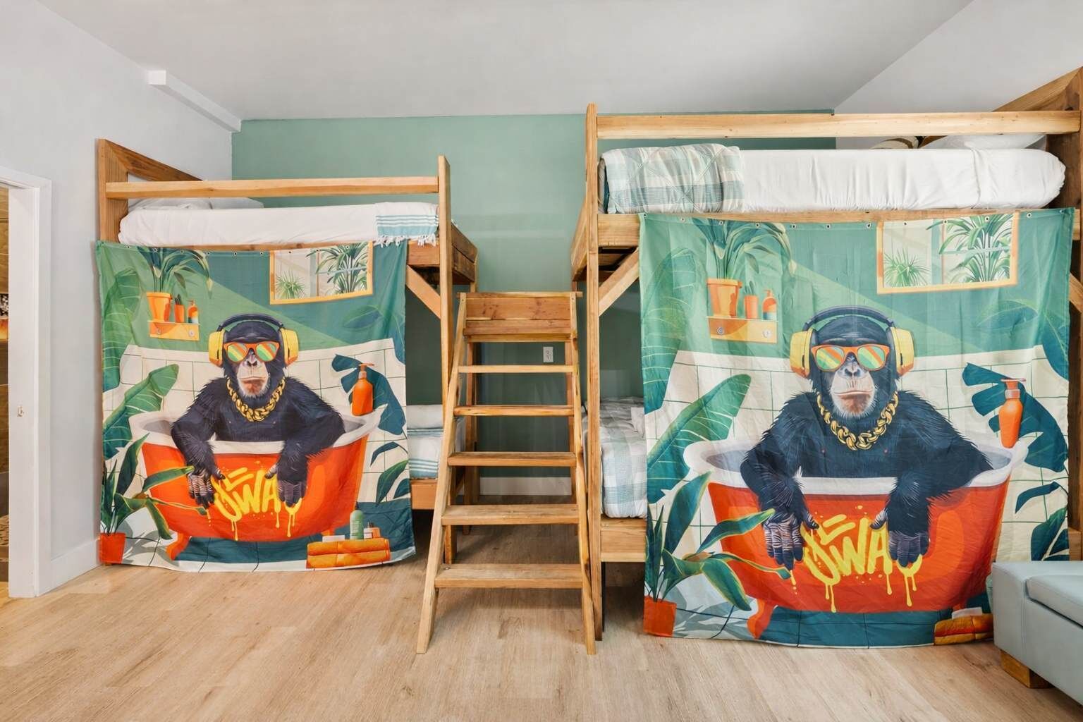 Una stanza con due letti a castello, ciascuno con un vivace murale raffigurante un gorilla nella vasca. Una scala di legno è posizionata tra i letti.
