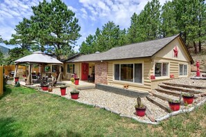 A log cabin with a porch, outdoor seating, and potted plants. - Pub -  Hot Tub - Fire Pit (Green Mountain Falls)
