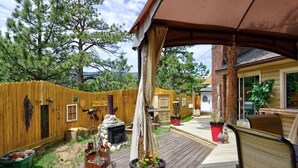 A wooden deck with a barbecue grill, a wooden fence, and potted plants. - Pub -  Hot Tub - Fire Pit (Green Mountain Falls)