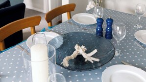 A dining table with a blue polka dot tablecloth, a decorative plate with a starfish, and blue salt and pepper shakers. - Coastal Retreat for 8 with Hot Tub - Walk to Beach (Chichester)