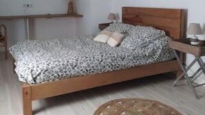 A bedroom with a wooden bed, a bedside table, a lamp, and a wall-mounted mirror. - Milady, Arcangues vacation rentals (Arcangues)