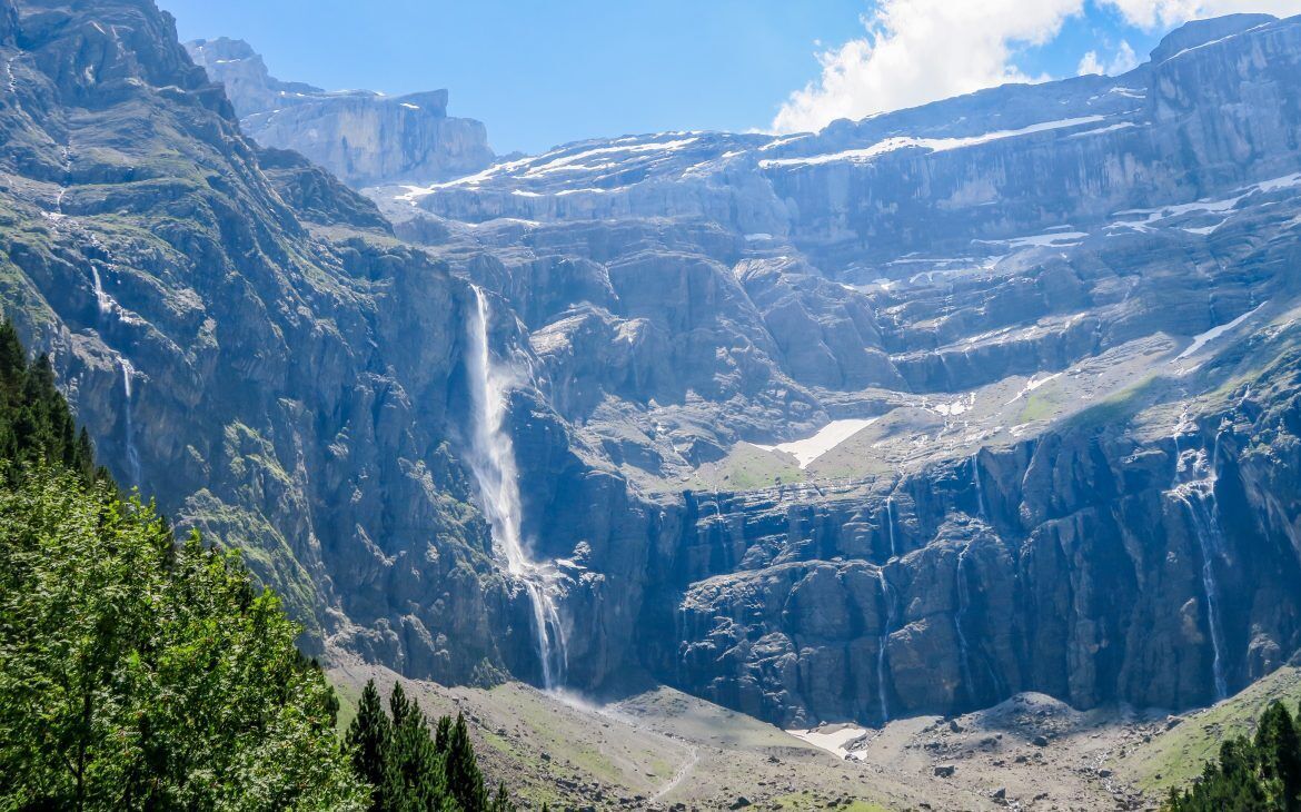 A mountainous landscape with a waterfall and a valley.