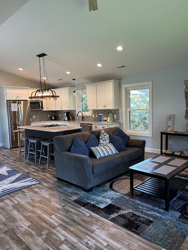 A modern kitchen with white cabinets, a stainless steel refrigerator, and a central island.