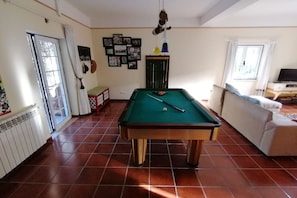 A billiards table in a room with tiled flooring, a sofa, a television, and a wall with framed pictures. - Geum Blue Apartment, Antanhol, Coimbra (Antanhol)