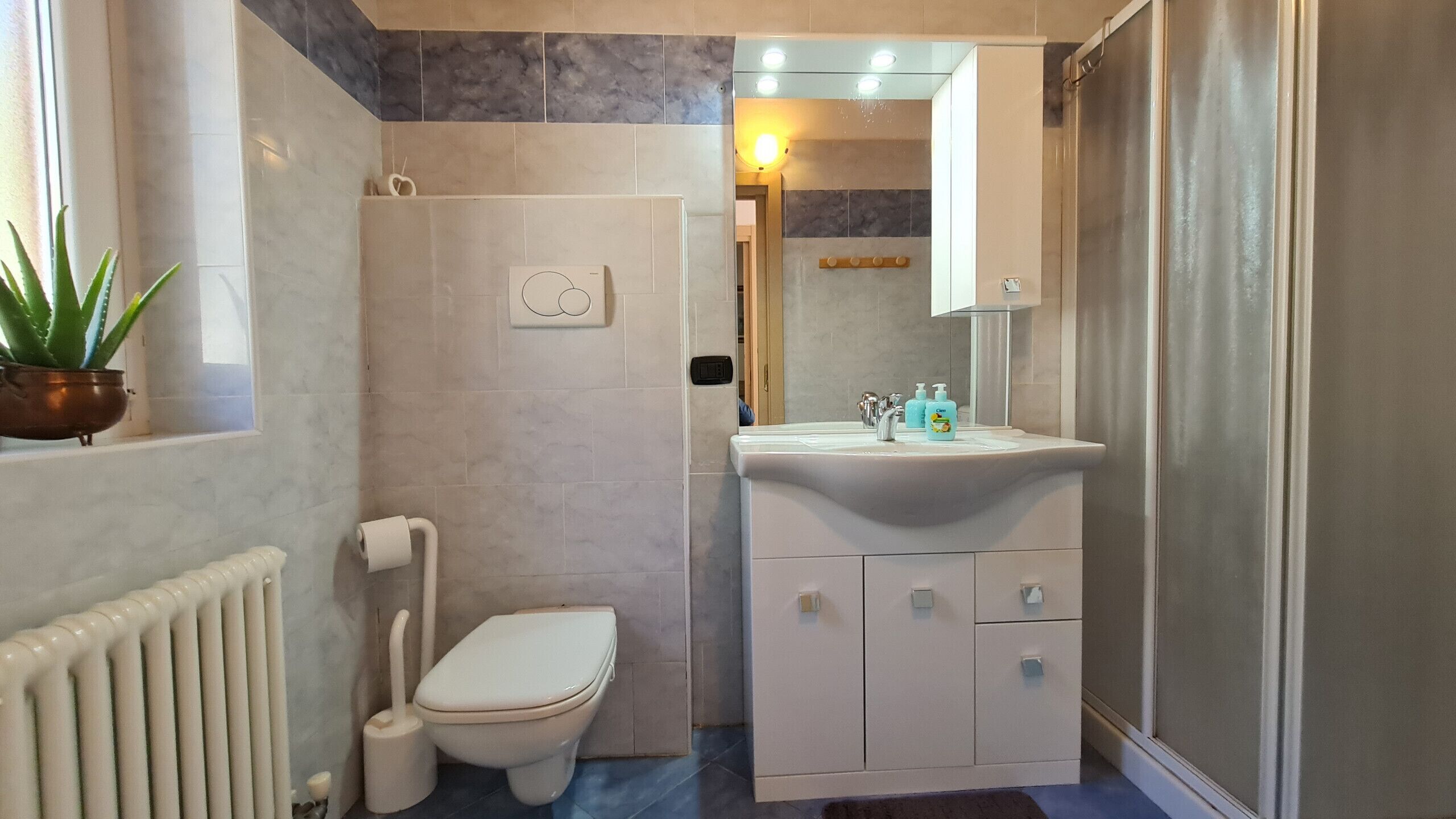 Un bany amb vàter, bidet, rentapel i articles de tocador, i un mirall.