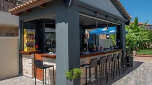 An outdoor bar area with a counter, bar stools, and a chalkboard menu. - Astarte Villas - Coco Palm Deluxe 2 Bedroom Apartment N3 (Ζακυνθος)